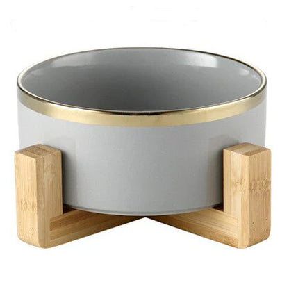 Elegant ceramic food bowl with gold rim and stable wooden base